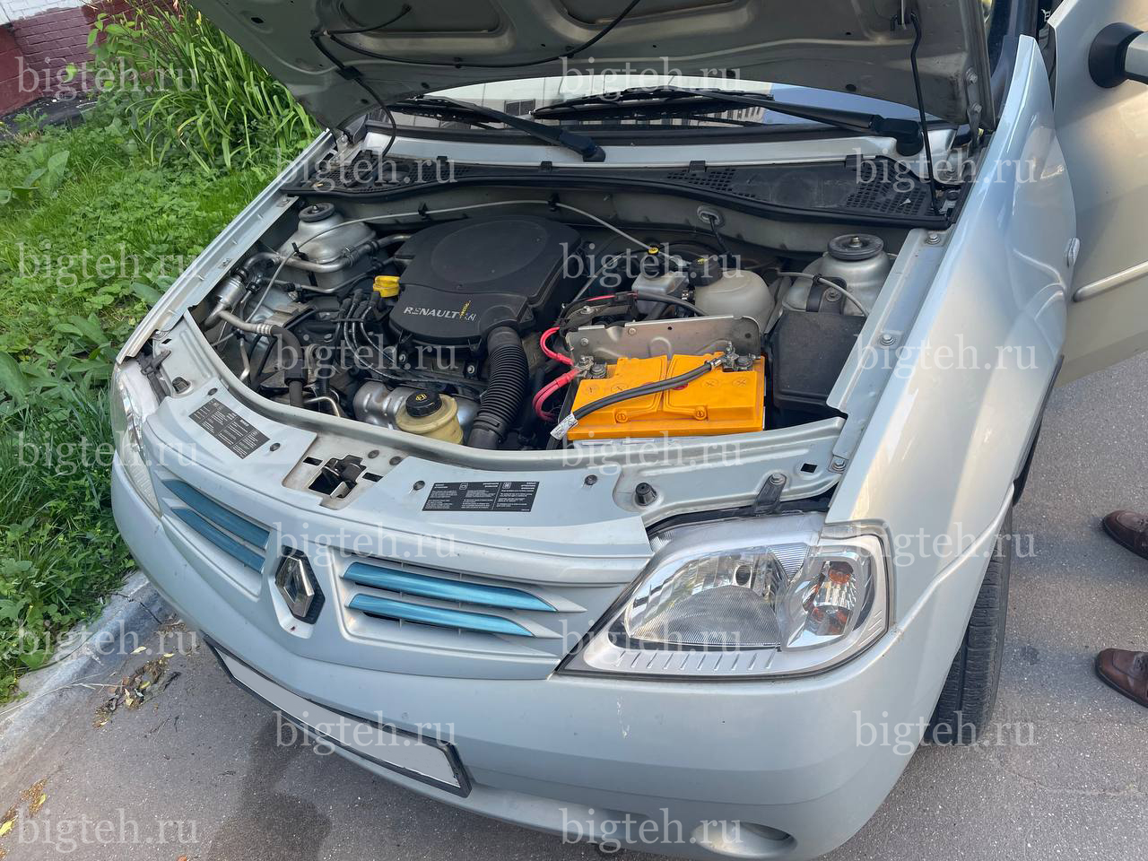Вид спереди. Замена аккумулятора на Renault Logan I бензин 1.6 (87/102 л.с.) 2004-2009 Вид спереди. Замена аккумулятора на Renault Logan I бензин 1.6 (87/102 л.с.) 2004-2009